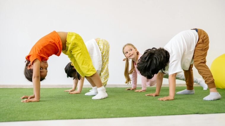 Happy children engaging in playful exercise and learning indoors, fostering group togetherness.