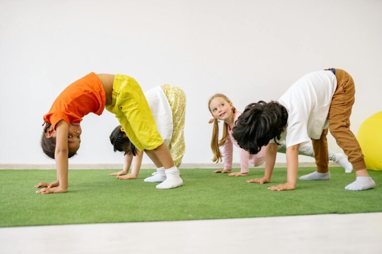 Happy children engaging in playful exercise and learning indoors, fostering group togetherness.