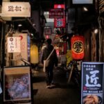 Explore Osaka's vibrant nightlife with a stroll through its illuminated alleys filled with signs and lanterns.