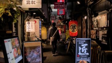 Explore Osaka's vibrant nightlife with a stroll through its illuminated alleys filled with signs and lanterns.