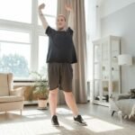A young man enjoying a morning stretch in a bright, airy living room, embracing a healthy lifestyle.