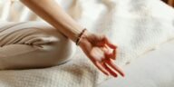 Serene image of a woman practicing meditation on a bed, embracing tranquility and relaxation.