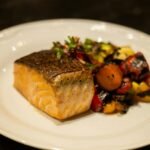 Delicious grilled salmon served with colorful roasted vegetables. Perfect for healthy dining.