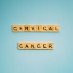 Scrabble tiles spelling 'Cervical Cancer' on a light blue background, symbolizing awareness.