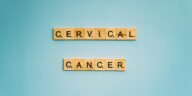 Scrabble tiles spelling 'Cervical Cancer' on a light blue background, symbolizing awareness.