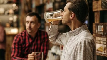 Two men enjoy refreshing draft beer in a cozy pub atmosphere.
