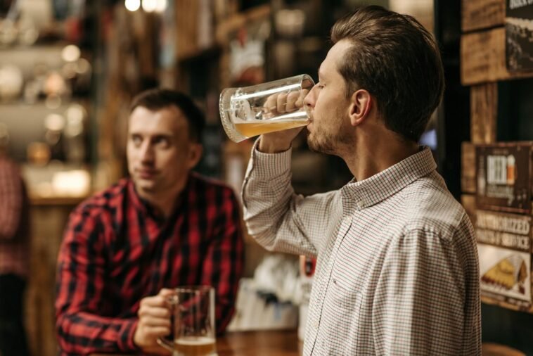 Two men enjoy refreshing draft beer in a cozy pub atmosphere.