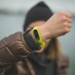 Close-up of a person holding up a fitness tracker, emphasizing technology and active lifestyle.