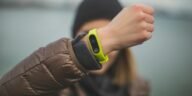Close-up of a person holding up a fitness tracker, emphasizing technology and active lifestyle.