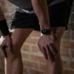 A close-up of an athlete resting after exercise, wearing a digital fitness watch.