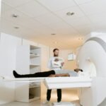 A doctor assists a patient during an MRI scan in a modern medical clinic.