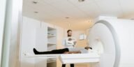 A doctor assists a patient during an MRI scan in a modern medical clinic.
