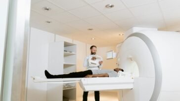 A doctor assists a patient during an MRI scan in a modern medical clinic.