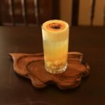 A delicious glass of Vietnamese egg coffee served on a wooden tray, captured in Hội An.