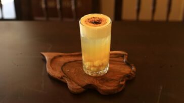 A delicious glass of Vietnamese egg coffee served on a wooden tray, captured in Hội An.