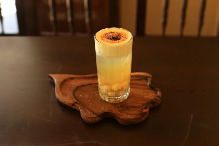 A delicious glass of Vietnamese egg coffee served on a wooden tray, captured in Hội An.
