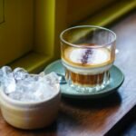 Glass of Vietnamese coffee and ice on a wooden sill in Da Nang's inviting cafe.