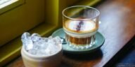 Glass of Vietnamese coffee and ice on a wooden sill in Da Nang's inviting cafe.