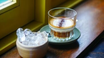 Glass of Vietnamese coffee and ice on a wooden sill in Da Nang's inviting cafe.