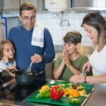 A happy family collaborates on a meal preparation in a stylish kitchen.
