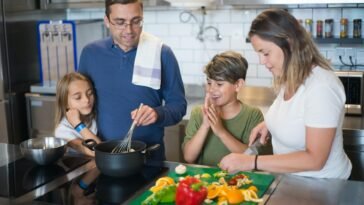 A happy family collaborates on a meal preparation in a stylish kitchen.