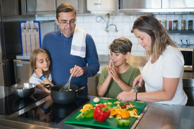 A happy family collaborates on a meal preparation in a stylish kitchen.