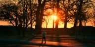 A person walks through Cove Island Park during a vivid autumn sunrise in Stamford, Connecticut.