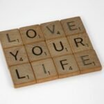 Scrabble tiles arranged to spell 'Love Your Life' against a white background, conveying a positive message.