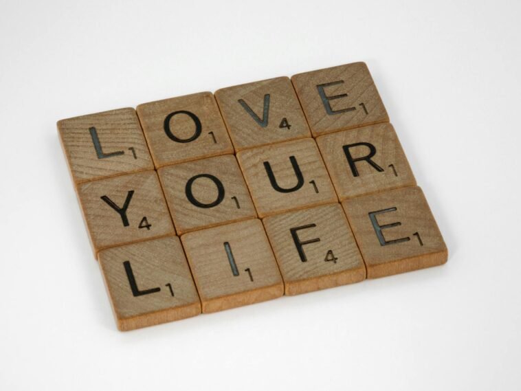 Scrabble tiles arranged to spell 'Love Your Life' against a white background, conveying a positive message.