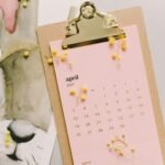 April 2021 calendar with watercolor bunny and mimosa flowers on clipboard.