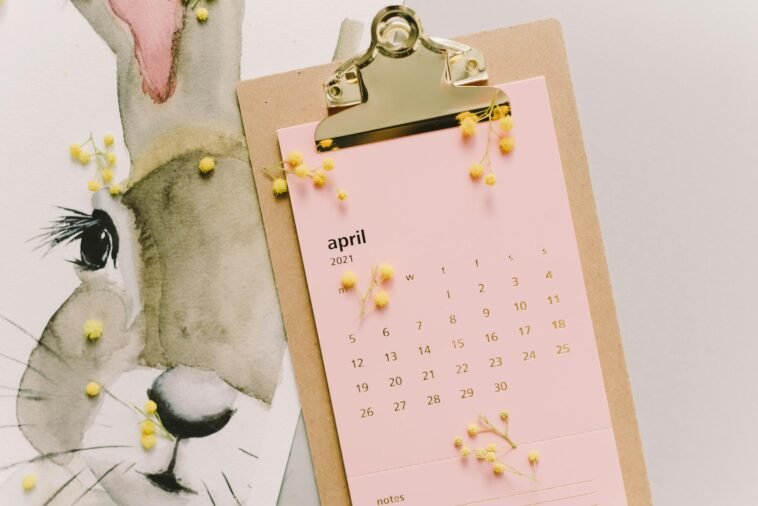 April 2021 calendar with watercolor bunny and mimosa flowers on clipboard.