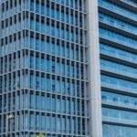 Close-up of a modern highrise building showcasing a glass facade with reflections.