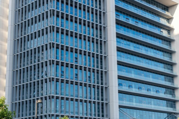 Close-up of a modern highrise building showcasing a glass facade with reflections.