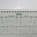 Close-up of a 2026 spiral-bound desk calendar with months in Portuguese.
